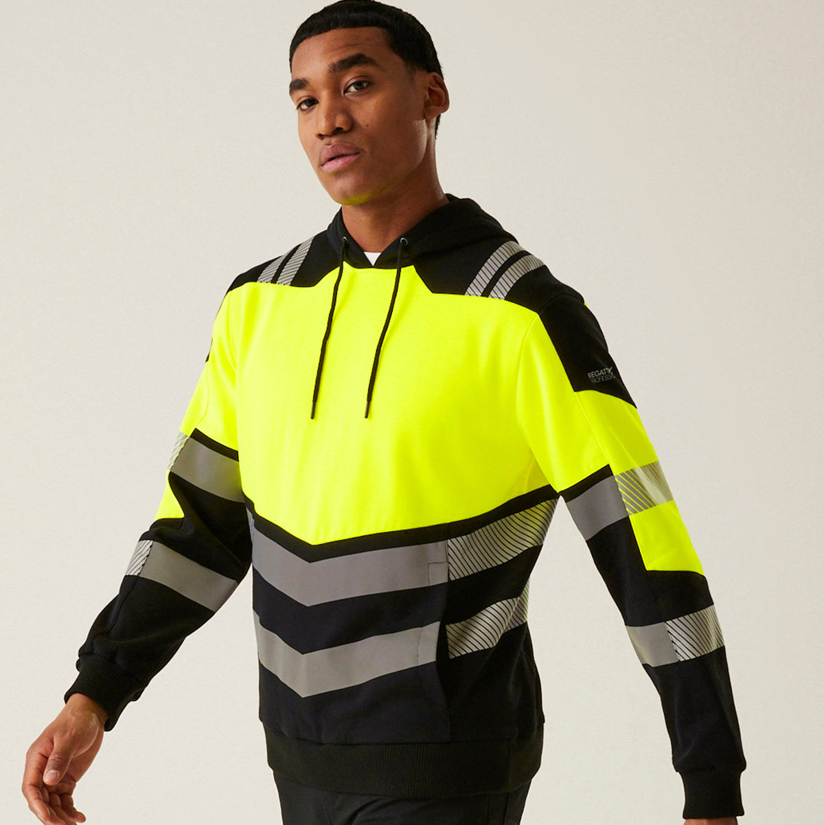 Person wearing a high-visibility safety jacket with reflective stripes on a plain background