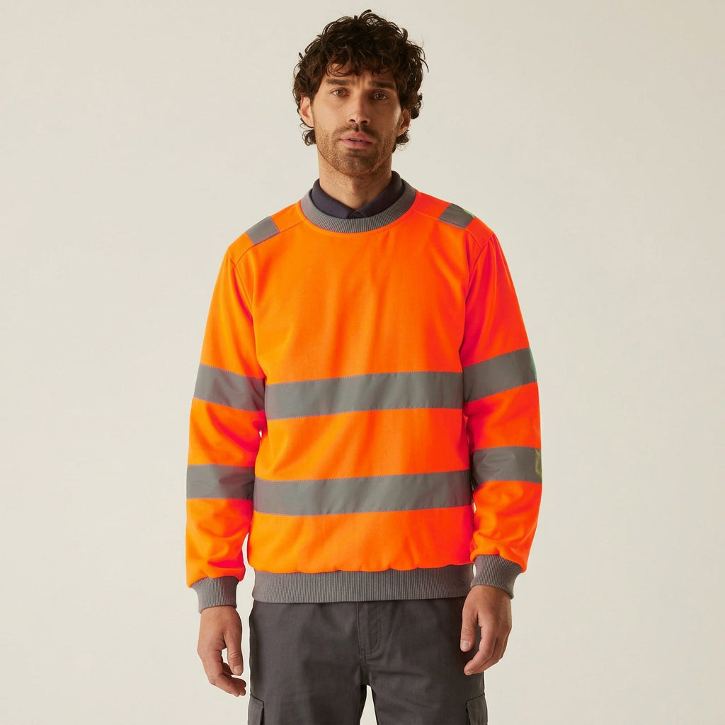 A man wearing a high-visibility orange work sweatshirt with reflective gray stripes, paired with matching orange trousers, against a plain light beige background.