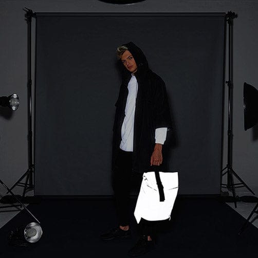 BagBase BG138 Reflective Roll-Top Backpack in dark conditions